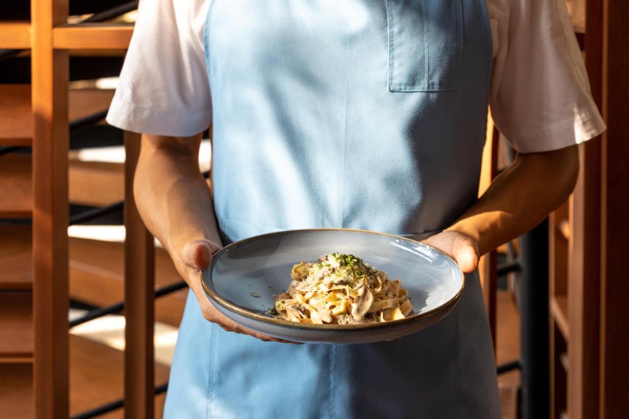 Outrigger Surin Beach Resort - Sha Extra Plus Exterior photo A server holding a plate of pasta